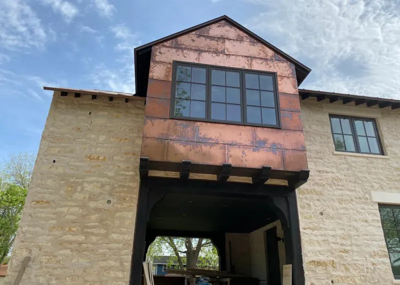 Copper metal panel facade on a stone building for Roof Repair in Geneseo
